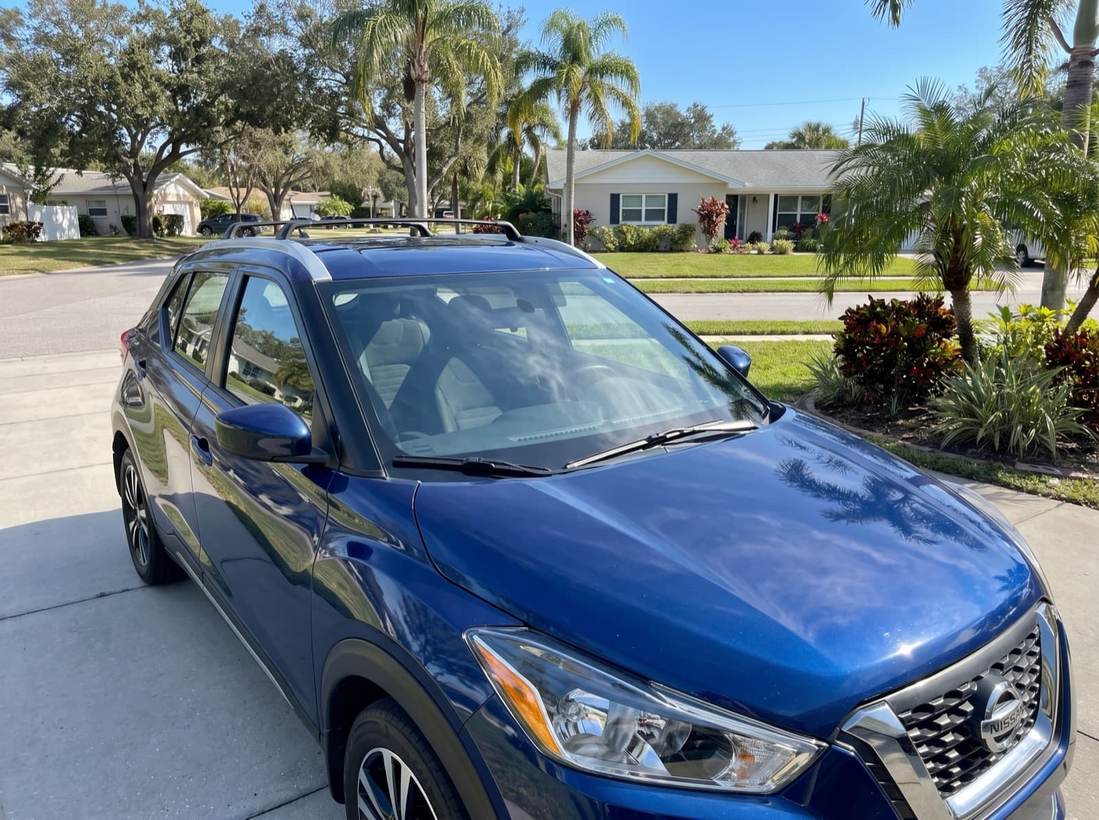 A blue compact SUV with roof rails in a driveway in Dunedin, FL, after a Bang AutoGlass mobile glass job