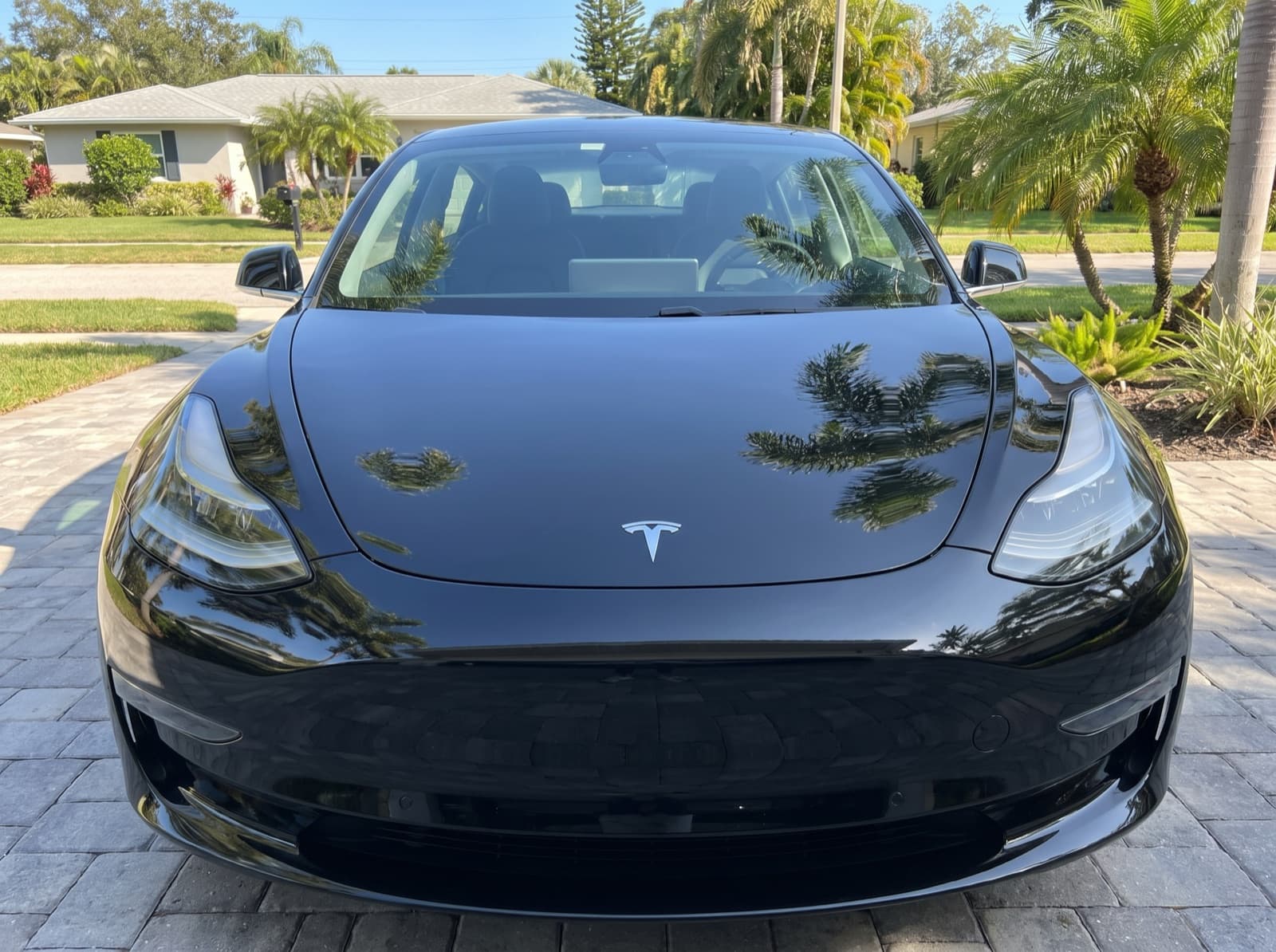 A black sedan on a paver driveway in St. Petersburg, FL, after a Bang AutoGlass mobile glass job
